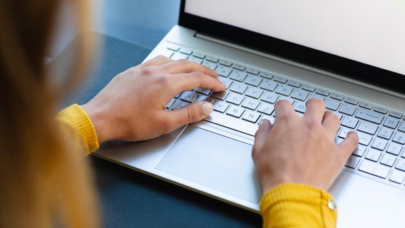 Eine Frau tippt auf der Tastatur eines Laptops. © picture alliance / Zoonar | Channel Partners 