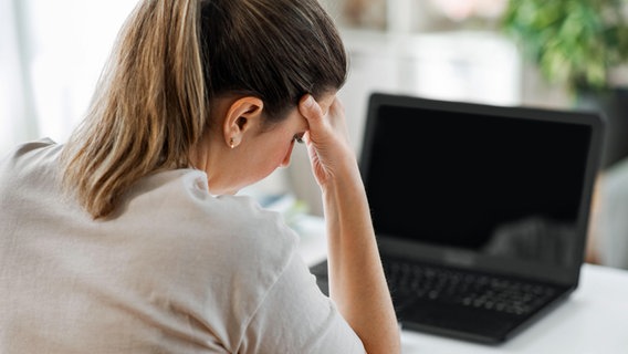 Eine gestresste Lehrerin sitzt vor einem Computer. © picture alliance / Zoonar Foto: lev dolgachov