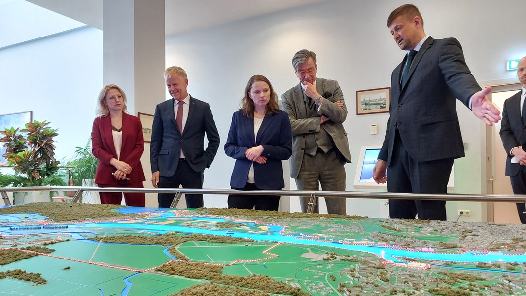 Hamburgs Sozialsenatorin schaut sich bei ihrer Baltikum-Reise ein Hafenmodell von Riga an. Der Hafen hat zuletzt stark an Umschlag verloren und setzt nun im Zug der digitalen Transformation auf neue Geschäfte.