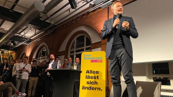 Der FDP-Parteichef steht bei einer Wahlkampf-Veranstaltung in Hamburg auf zwei Stühlen und hält eine Rede. © NDR Foto: Jenny Witt