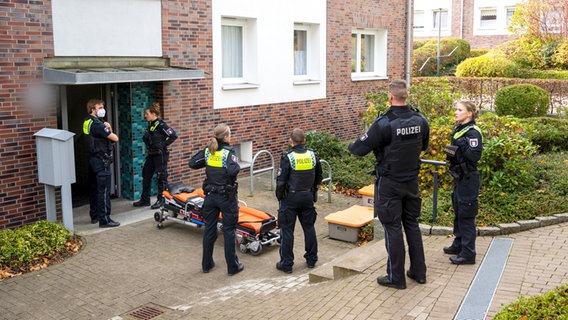 Einsatzkräfte der Polizei stehen im Stadtteil Lohbrügge vor einem Mehrfamilienhaus. © Daniel Bockwoldt/dpa 