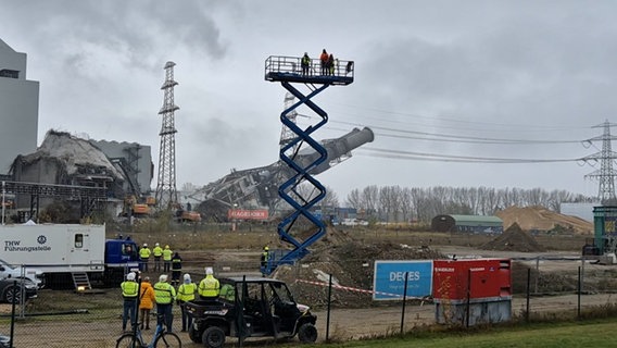 Der Doppel-Schornstein des Kraftwerks Moorburg in Hamburg kippt nach seiner Sprengung um. © NDR Foto: Karsten Sekund