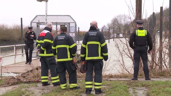 Mehrere Feuerwehreinsatzkräfte stehen an einem See. © TV Newskontor 