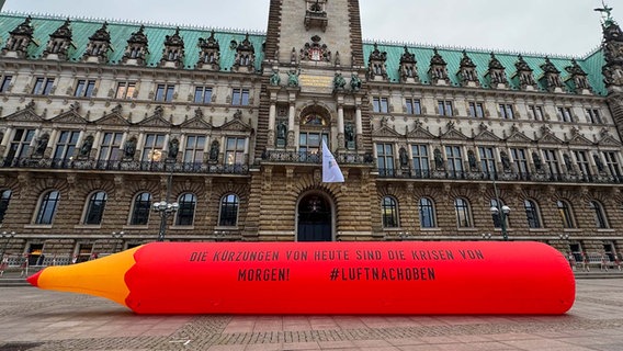 Vor dem Hamburger Rathaus ist anlässlich der Nachhaltigkeitskonferenz ein luftgefüllter Rotstift aufgebaut mit der Aufschrift "Die Kürzungen von heute sind die Krisen von morgen" © NDR Foto: Anna Rüter