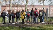 Schüler stehen auf dem Gelände des ehemaligen Konzentrationslagers Neuengamme. © picture alliance Foto: Markus Scholz