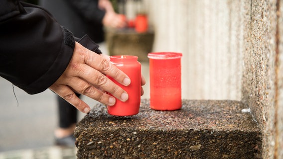 Jemand zündet auf dem Friedhof Ohlsdorf Kerzen fuer die Opfer des Nationalsozialismus an. © picture alliance Foto: Christin Klose