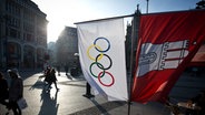 Flaggen mit den Olympischen Ringen und dem Wappen von Hamburg hängen am Rathausmarkt. (Archivfoto) © picture alliance / dpa Foto: Christian Charisius