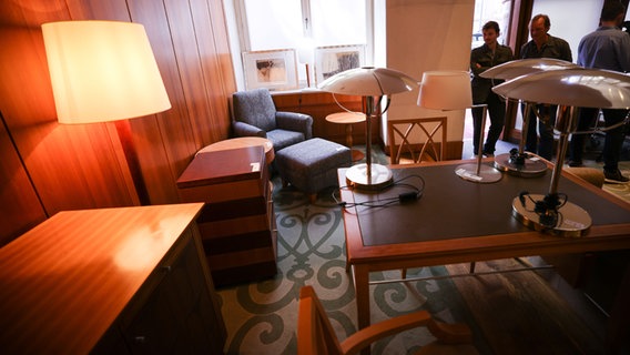 Interessenten stehen zwischen Möbeln und Lampen in den Räumen des ehemaligen Hotel "Park Hyatt" in der Innenstadt. © dpa Foto: Christian Charisius
