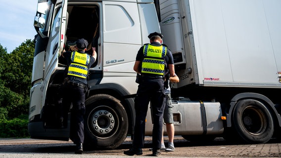 Polizisten überprüfen während einer Verkehrskontrolle einen Lastwagen. © Daniel Bockwoldt/dpa Foto: Daniel Bockwoldt