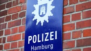 Nahaufnahme eines Schildes mit dem Logo und Schriftzug Polizei Hamburg. © picture alliance / Maximilian Koch Foto: Maximilian Koch