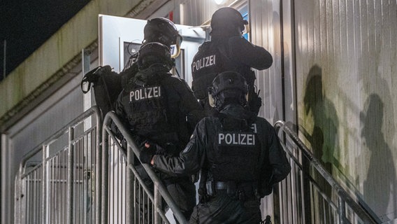 Polizisten dringen in eine Flüchtlingsunterkunft im Hamburger Stadtteil Neuenfelde ein. In einem Wohnheim für Geflüchtete gab es eine größere Schlägerei. © picture alliance/dpa/NEWS5 Foto: René Schröder