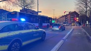 Ein Polizeiwagen steht vor einem Bus, der an einer Ampel hält. © TV Newskontor 