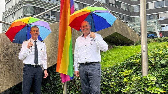 Polizei-Vizepräsident Mirko Streiber hisst gemeinsam mit Heiko Jensen von Hamburg Pride eine Regenbogenflagge am Hamburger Polizeipräsidium. © NDR Foto: Finn Kesler