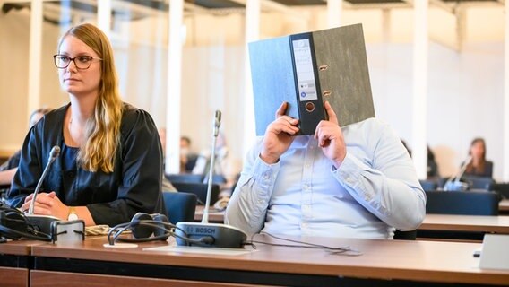 Der Angeklagte sitzt vor Beginn der Verhandlung neben seiner Verteidigerin im Gerichtssaal. © Jonas Walzberg/dpa Foto: Jonas Walzberg