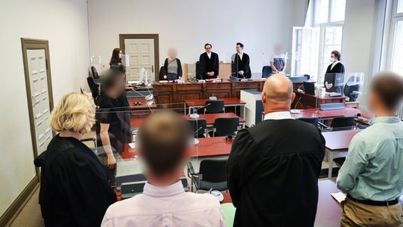 Der Hauptangeklagte (2.v.l), und weitere Prozessbeteiligte im Gerichtssaal im Strafjustizgebäude. (Archivfoto vom Prozessauftakt) © Christian Charisius/dpa 