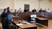 Personen sitzen in einem Gerichtssaal. © NDR/Elke Spanner Foto: Elke Spanner