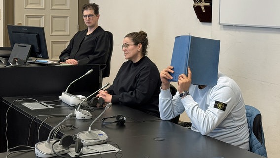 Ein Angeklagter verbirgt bei einem Prozess in Hamburg sein Gesicht. © NDR Foto: Elke Spanner