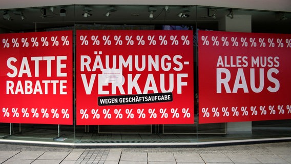 Schilder mit der Aufschrift "Räumungsverkauf wegen Geschäftsaufgabe" hängen in einem Schaufenster. © Weber/ Eibner-Pressefoto 