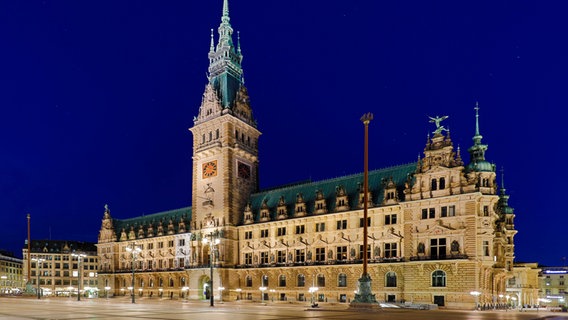 Das Hamburger Rathaus ist in der Dunkelheit beleuchtet © IMAGO / blickwinkel 