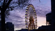 Herrliche Abendstimmg: Das Riesenrad auf dem Winterdom auf dem Heiligengeistfeld ist beleuchtet zu sehen. © Marcus Brandt/dpa Foto: Marcus Brandt