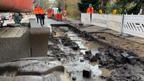 Bauarbeiten stehen auf einer Straße mit einem Wasserrohrburch. © NDR Foto: Screenshot