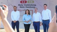 Verkehrssenator Anjes Tjarks (Grüne), Ingrid Felipe (Deutsche Bahn), Andreas Hoffknecht (DB Energie) und Jan Schröder (S-Bahn Hamburg) stehen beim symbolischen Bauauftakt zusammen. © dpa Foto: Bodo Marks