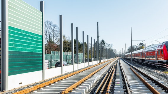 Eine Regionalbahn fährt an der Lärmschutzwand der Ausbaustrecke der S-Bahn-Linie 4 vorbei. © picture alliance / dpa Foto: Markus Scholz