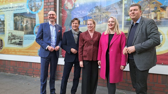 Finanzsenator Andreas Dressel (SPD) steht mit weiteren Projektbeteiligten vor dem Schaufenster des ehemaligen Karstadthauses in Harburg. © NDR Foto: Petra Volquardsen