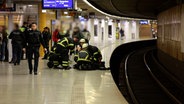 An einer S-Bahn Station stehen mehrere Polizisten und Sanitäter um einen Mann, der auf dem Boden liegt. © TV-Newskontor 