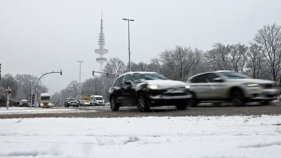 Fahrzeuge sind in Hamburg nach starkem Schneefall auf einer Hauptverkehrsstraße unterwegs. © picture alliance / dpa Foto: Christian Charisius