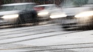 Fahrzeuge sind bei Schneefall auf einer Hauptverkehrsstraße in Hamburg unterwegs. © dpa Foto: Christian Charisius