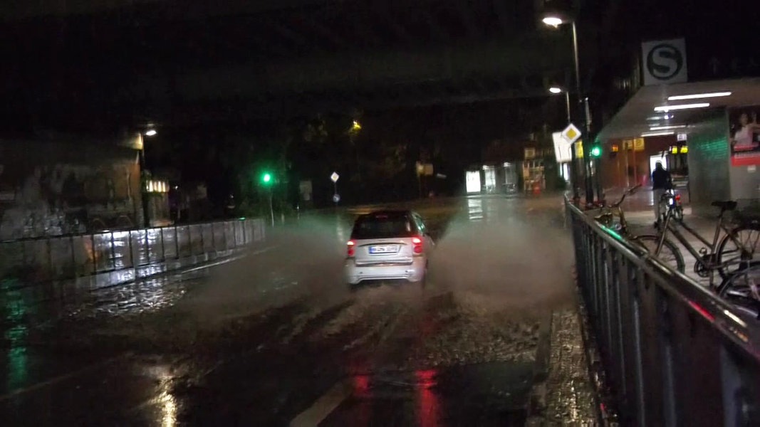 Ein Auto fährt durch eine überflutete Unterführung in Hamburg.