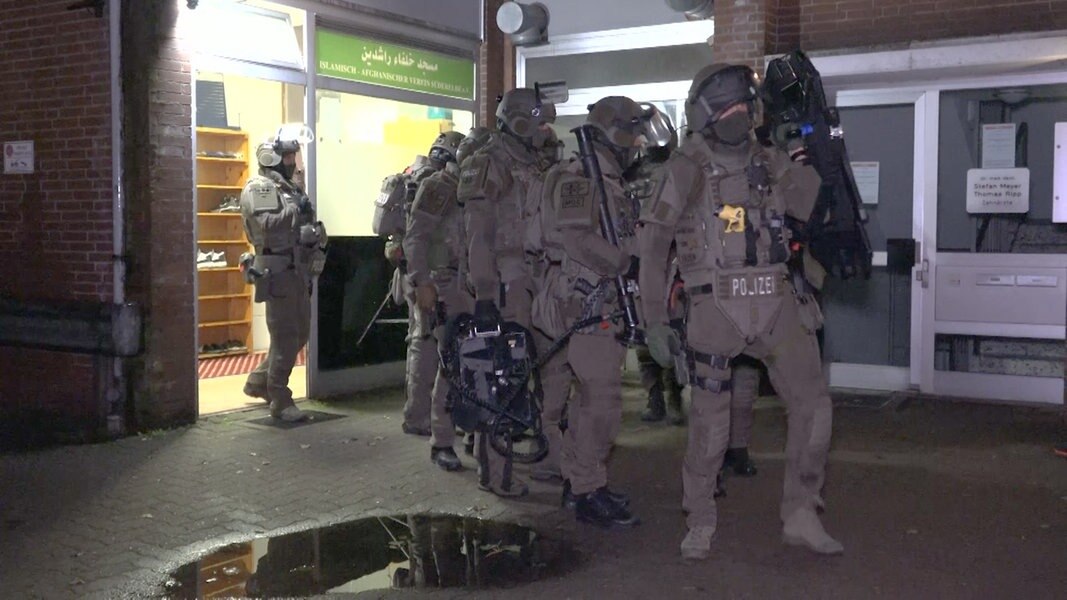 Mehrere Einsatzkräfte der Polizei stehen vor einem Einsatzort in Hamburg.