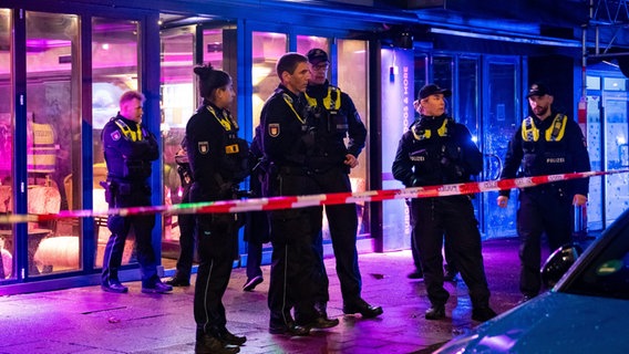 Polizisten stehen in Hamburg vor einem abgesperrten Lokal. In der Shisha-Bar hatte es zuvor eine Schlägerei gegeben. © picture alliance / dpa Foto: Jonas Walzberg