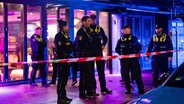 Polizisten stehen in Hamburg vor einem abgesperrten Lokal. In der Shisha-Bar hatte es zuvor eine Schlägerei gegeben. © picture alliance / dpa Foto: Jonas Walzberg