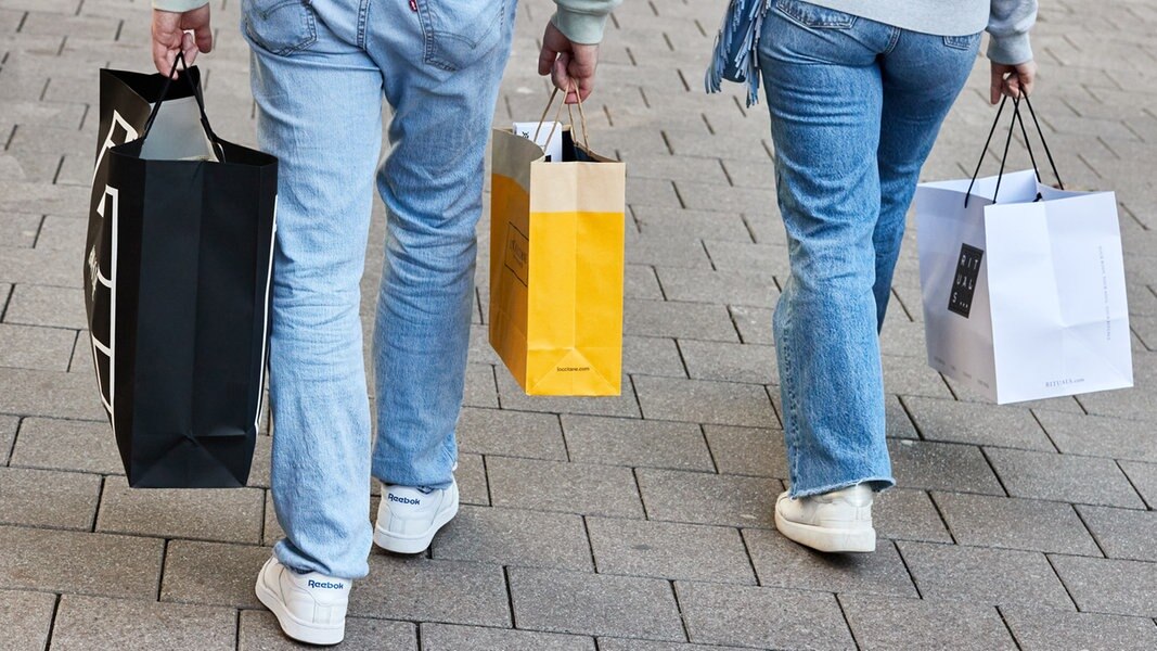 Eine Frau und ein Mann tragen mehrere Einkaufstüten am verkaufsoffenen Sonntag auf der Mönckebergstraße.