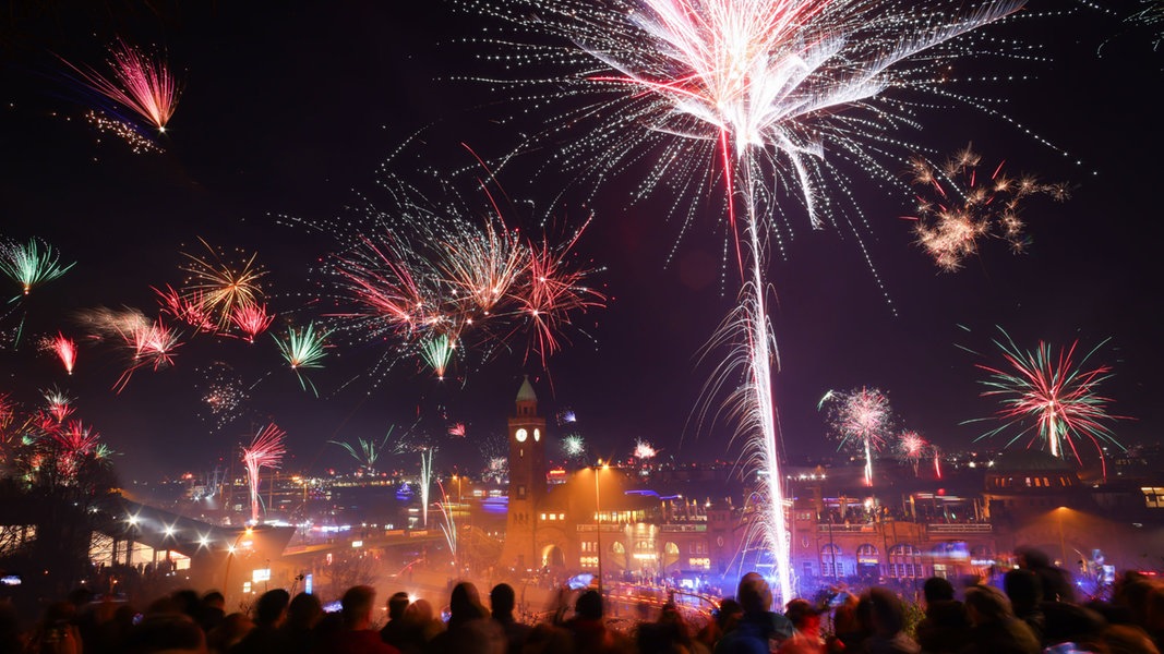  Zahlreiche Menschen feiern den Jahreswechsel in Hamburg an den Landungsbrücken am Hafen.