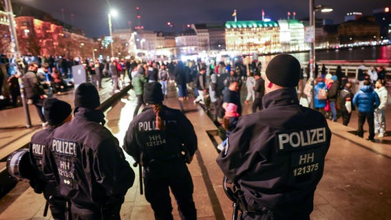 Polizeikräfte stehen auf dem Jungfernstieg und kontrollieren das Verbot von Feuerwerk an der Binnenalster kurz vor dem Jahreswechsel. © picture alliance / dpa Foto: Christian Charisius