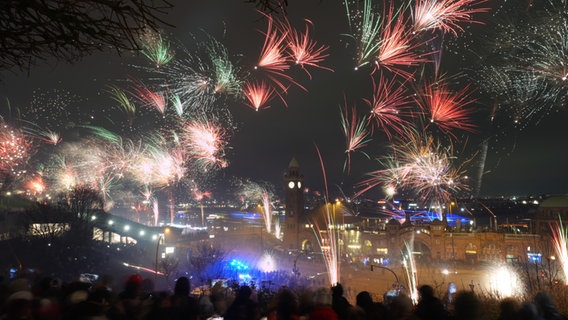 Zahlreiche Menschen feiern mit Feuerwerk den Jahreswechsel an den Landungsbrücken im Hamburger Hafen. © picture alliance/dpa | Marcus Brandt Foto: Marcus Brandt