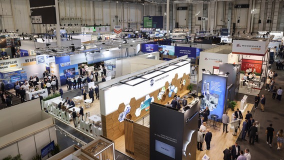 Besucherinnen und Besucher sind auf der Schiffbaumesse SMM unterwegs. © Christian Charisius/dpa 