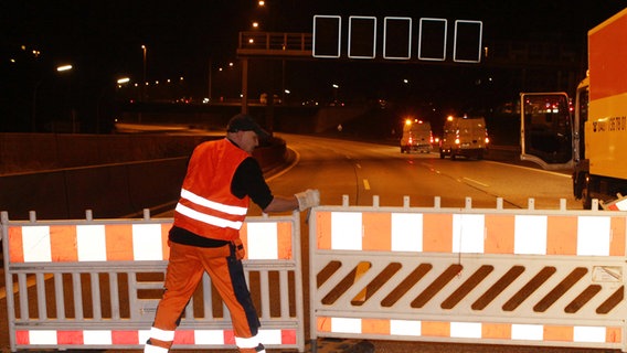 Ein Bauarbeiter bereitet die Sperrung der Autobahn 7 in Hamburg-Stellingen vor. © dpa Foto: Malte Christians