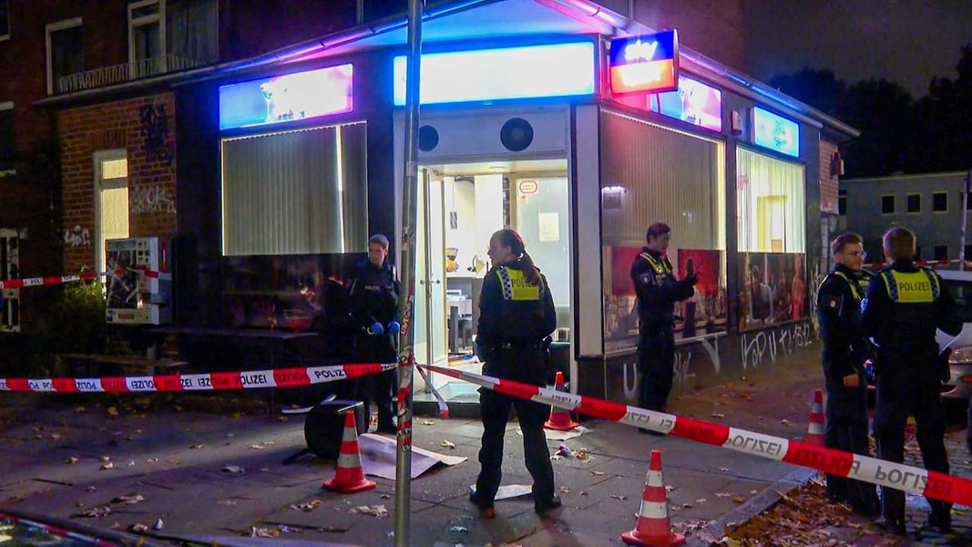 Einsatzkräfte der Polizei stehen vor einer Sportsbar in Hamburg.