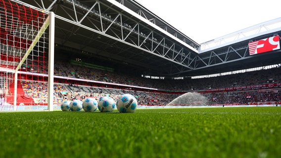 Mehrere Fußbälle liegen neben dem Tor im Stadion von Fortuna Düsseldorf. © IMAGO / kolbert-press 