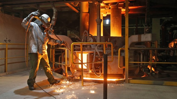 Ein Schmelzer misst die Temperatur in einem Pfannenofen in der Stahlwerkshalle von ArcelorMittal in Hamburg. © picture alliance / dpa Foto: Christian Charisius