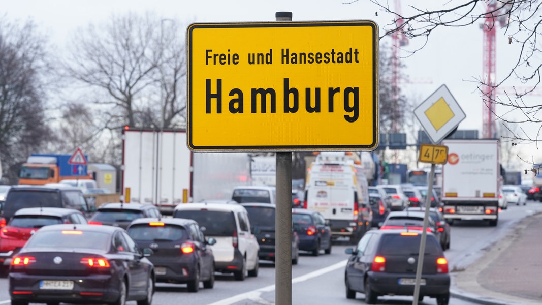 Autos und Lastwagen stehen in Hamburg im Bereich der Elbbrücken im Stau. Im Vordergrund ist ein Ortsschild mit der Aufschrift 