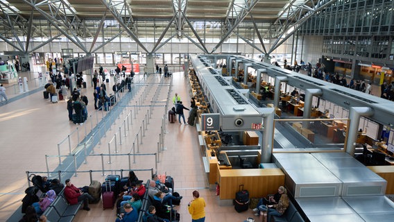 Passagiere stehen vor Schaltern am Flughafen in Hamburg. Die Schalter sind alle unbesetzt. © dpa-bildfunk Foto: Georg Wendt