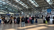 Mehrere Personen warten aufgrund eines Streiks am Hamburger Flughafen. © NDR Foto: Karsten Sekund