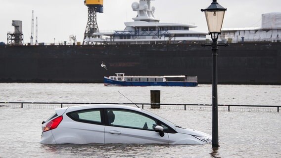 Ein Auto steht auf dem Hamburger Fischmarkt während einer Sturmflut im Wasser der Elbe. © dpa Foto: Daniel Bockwoldt