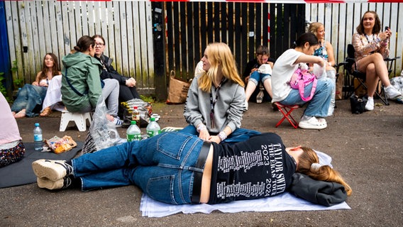 Eine junge Frau liegt auf der Seite und trägt ein Taylor Swift T-Shirt. © dpa Foto: Daniel Bockwoldt