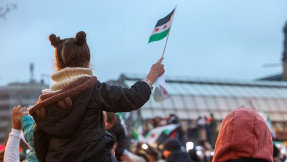 Zahlreiche Menschen feiern am Hachmannplatz am Hauptbahnhof den Sturz von Syriens Machthaber Assad. © picture alliance/dpa | Bodo Marks Foto: Bodo Marks